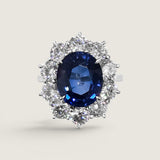4.5ct Oval Cut Center sapphire surrounded by 12 Round Cut Stones of 2.5 TCW. Center stone size: 12x10mm F233-SAP-CZ-14K