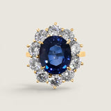 4.5ct Oval Cut Center sapphire surrounded by 12 Round Cut Stones of 2.5 TCW. Center stone size: 12x10mm F233-SAP-CZ-14K