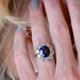 4.5ct Oval Cut Center sapphire surrounded by 12 Round Cut Stones of 2.5 TCW. Center stone size: 12x10mm F233-SAP-CZ-14K